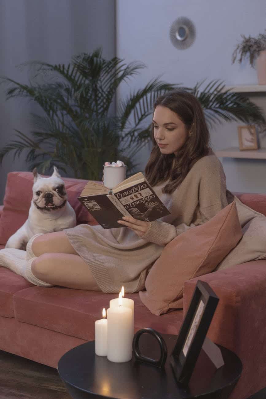 woman sitting on couch while reading a book